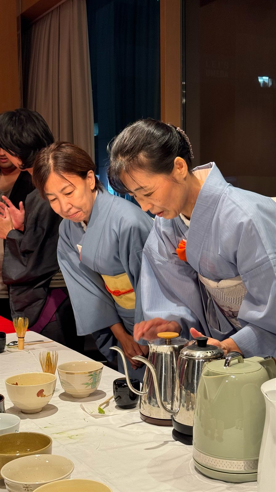 着物のスタッフが抹茶を点てているところ
