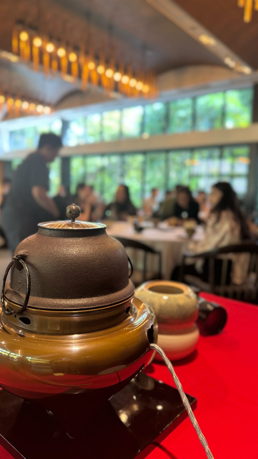 茶釜と、その奥で円卓に座るお客様