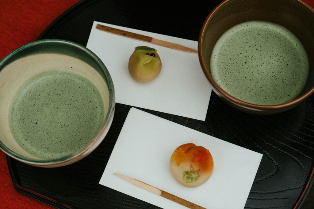 Artistic presentation of matcha tea and wagashi sweets in a traditional Japanese tea ceremony setting.